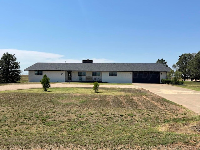 ranch-style house featuring concrete driveway, a garage, and a front yard