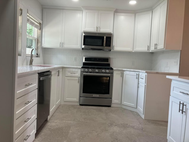 3704 Westlawn Ave, Amarillo, TX 79102 - kitchen featuring stainless steel appliances, backsplash, light countertops, white cabinetry, and recessed lighting