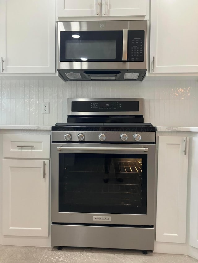 3704 Westlawn Ave, Amarillo, TX 79102 - kitchen featuring appliances with stainless steel finishes, light countertops, decorative backsplash, and white cabinets