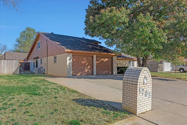 exterior space with central AC, an outbuilding, a front lawn, and a garage