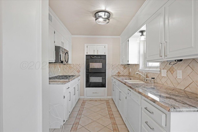 kitchen featuring decorative backsplash, sink, white cabinets, and appliances with stainless steel finishes