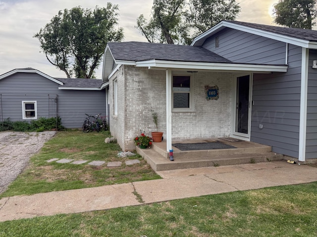 1105 Main St, Panhandle, TX 79068 - entrance to property featuring a shingled roof and brick siding