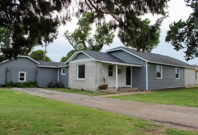 1105 Main St, Panhandle, TX 79068 - ranch-style house featuring driveway, a front yard, brick siding, and roof with shingles