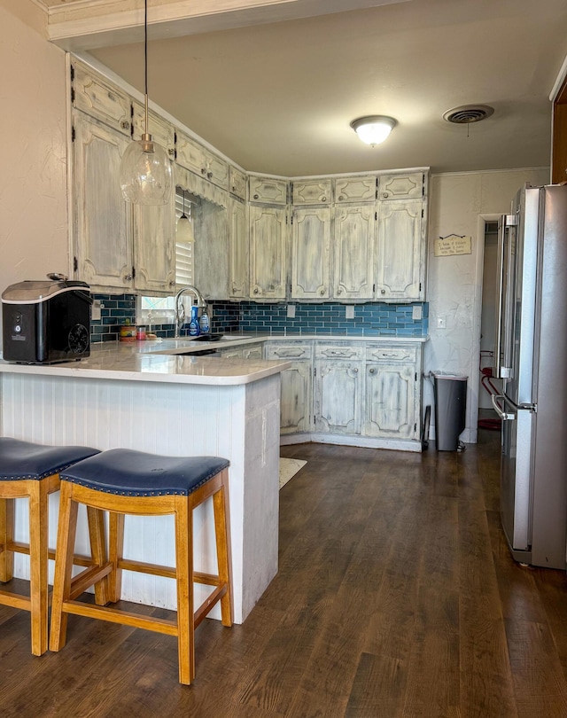 1105 Main St, Panhandle, TX 79068 - kitchen featuring high quality fridge, a peninsula, tasteful backsplash, and light countertops