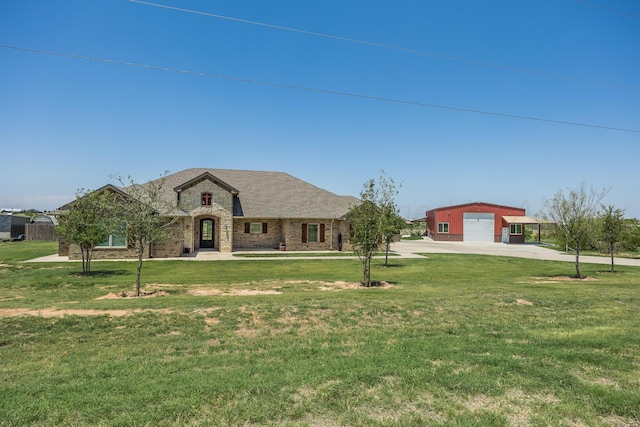 view of front of house with a garage, an outbuilding, and a front lawn