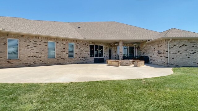 back of house featuring a lawn and a patio