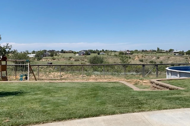 view of yard featuring a rural view and a fenced in pool