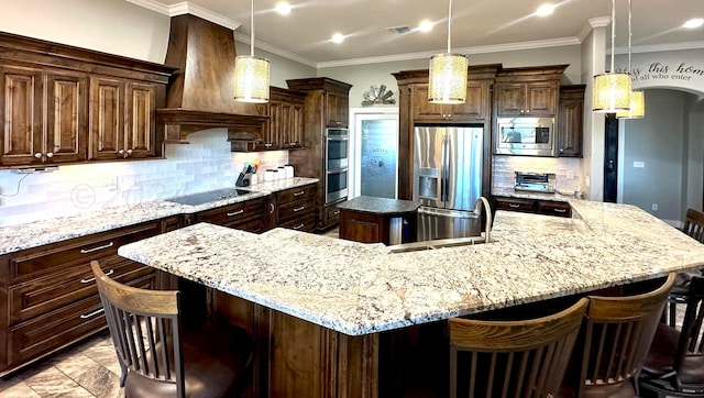 kitchen featuring a large island, premium range hood, stainless steel appliances, and decorative light fixtures