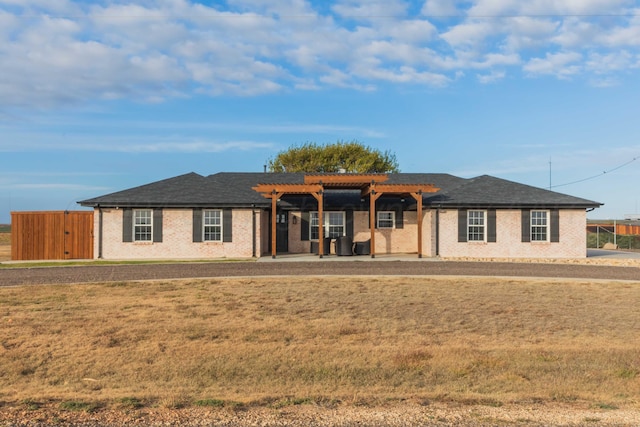 view of front facade with a front yard and a pergola