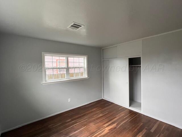 1605 S Colgate St, Perryton, TX 79070 - unfurnished bedroom featuring dark wood finished floors and a closet