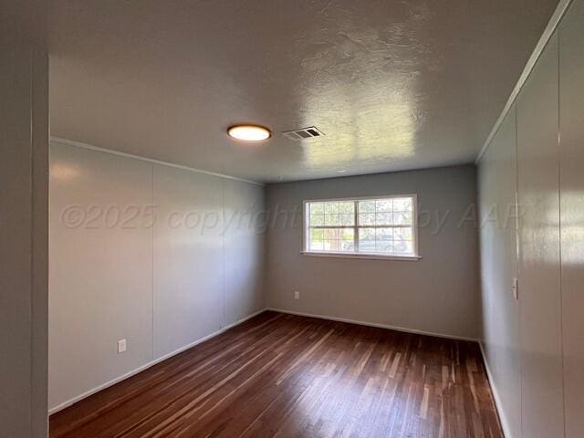 1605 S Colgate St, Perryton, TX 79070 - spare room featuring dark wood finished floors and baseboards