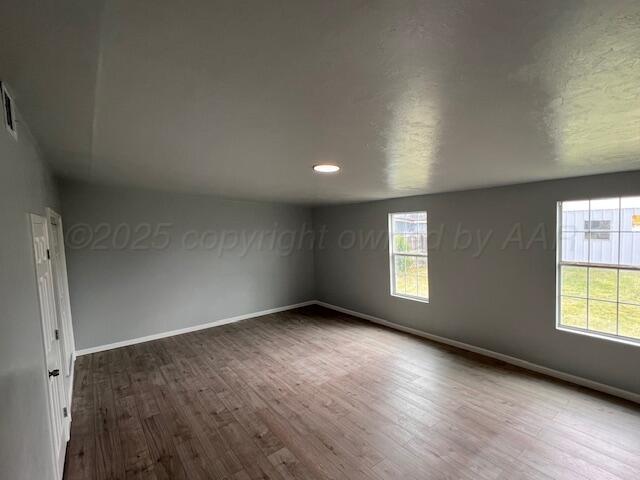 1605 S Colgate St, Perryton, TX 79070 - empty room with wood finished floors and baseboards