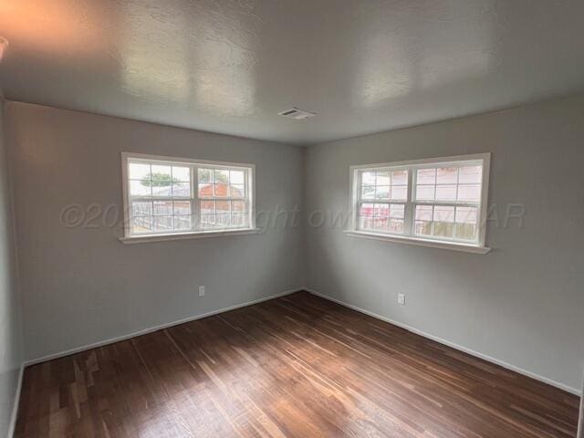 1605 S Colgate St, Perryton, TX 79070 - empty room featuring wood finished floors and plenty of natural light