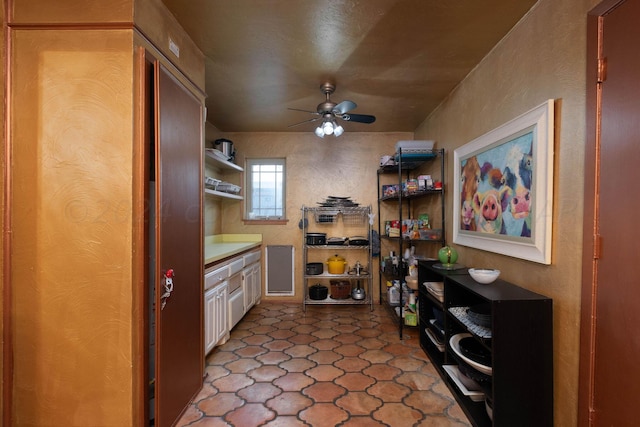 kitchen featuring white cabinetry and ceiling fan