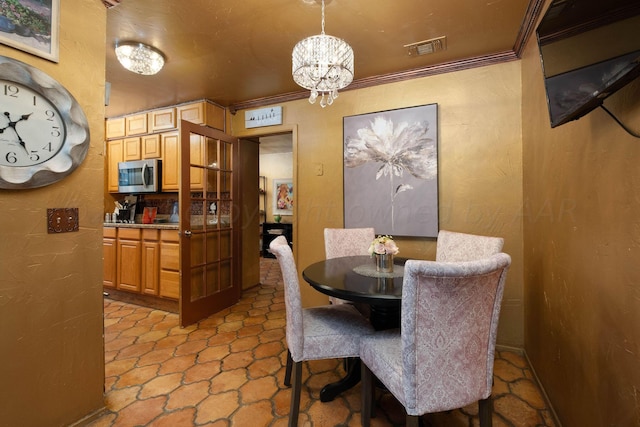 dining room featuring a notable chandelier and ornamental molding