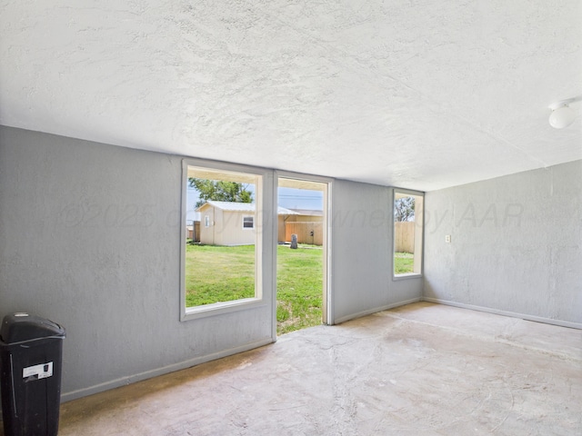803 R Ave, Sunray, TX 79086 - unfurnished room featuring a textured ceiling, plenty of natural light, and concrete floors