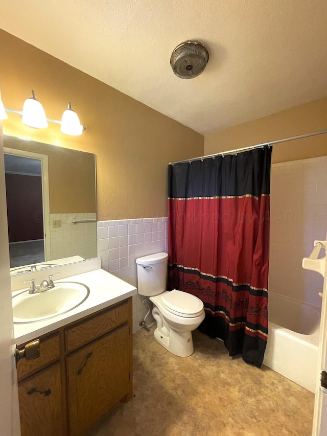 full bathroom with shower / bath combination with curtain, a textured ceiling, vanity, toilet, and tile walls