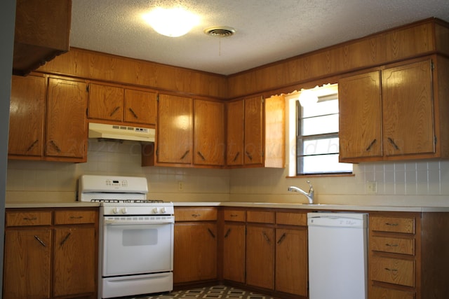 kitchen featuring white appliances, a textured ceiling, sink, and decorative backsplash