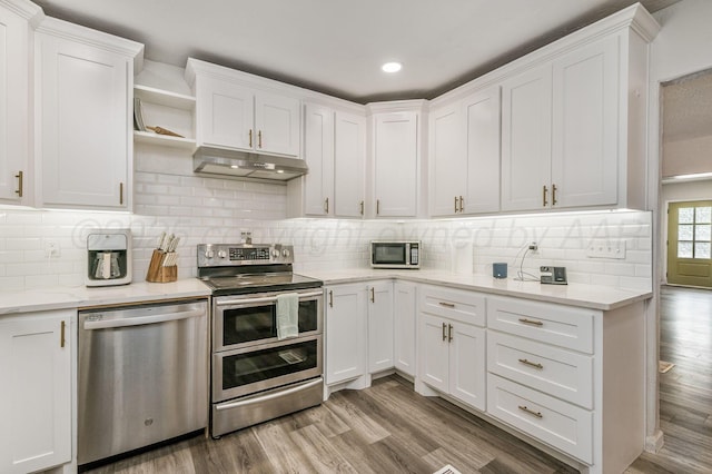 1033 Bowie St, Amarillo, TX 79102 - kitchen featuring appliances with stainless steel finishes, under cabinet range hood, white cabinets, light wood-style floors, and recessed lighting