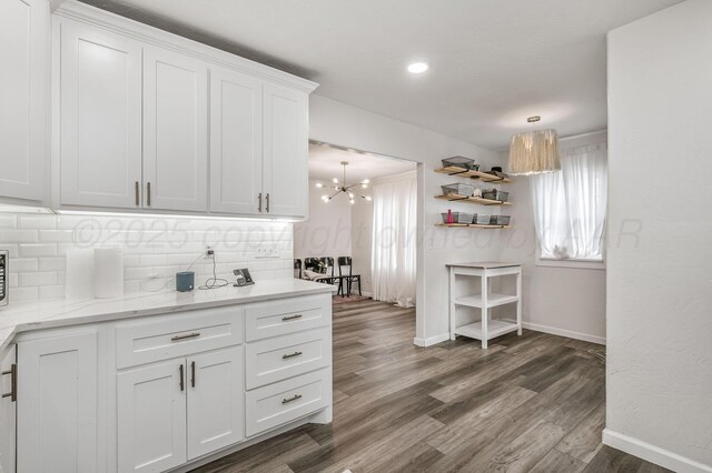 1033 Bowie St, Amarillo, TX 79102 - kitchen with backsplash, baseboards, white cabinetry, a chandelier, and wood finished floors
