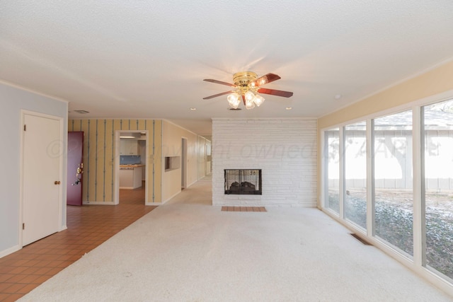 unfurnished living room featuring light carpet, a brick fireplace, visible vents, and a textured ceiling