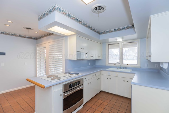 kitchen with light countertops, white appliances, white cabinets, and a sink