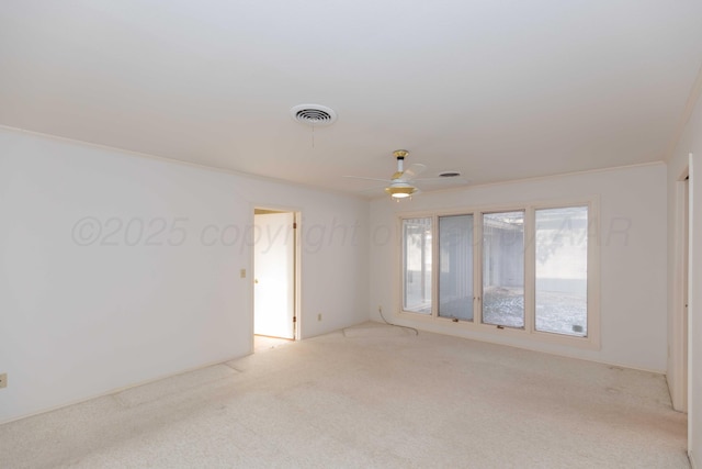 unfurnished room featuring a ceiling fan, light colored carpet, and visible vents