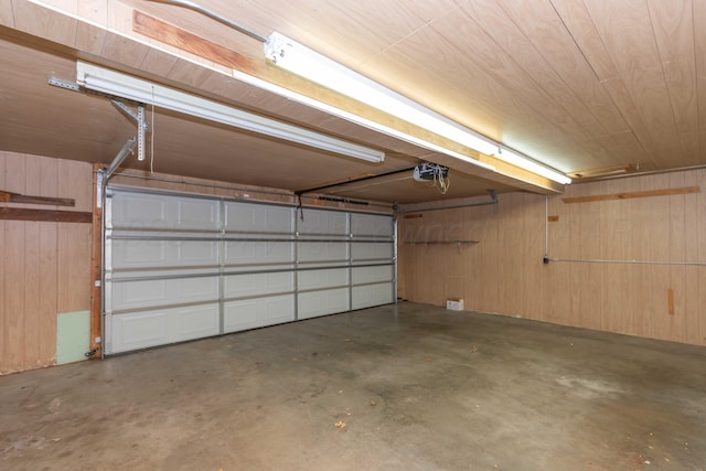 garage featuring wood walls and a garage door opener