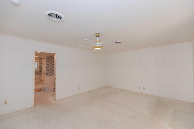 spare room with ceiling fan, visible vents, carpet flooring, and ornamental molding