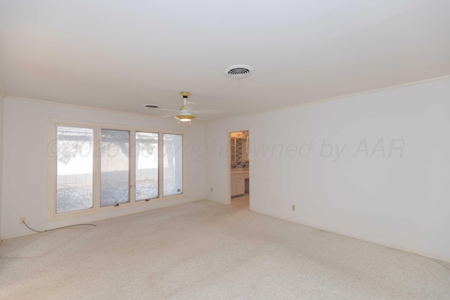 empty room featuring a ceiling fan, light carpet, and visible vents