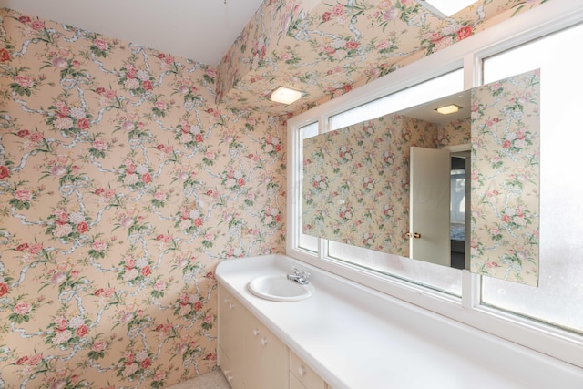 bathroom with vanity and wallpapered walls