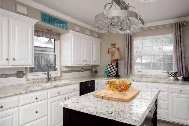 4214 Roxton Dr, Amarillo, TX 79109 - kitchen with black dishwasher, white cabinets, backsplash, ornamental molding, and light stone countertops