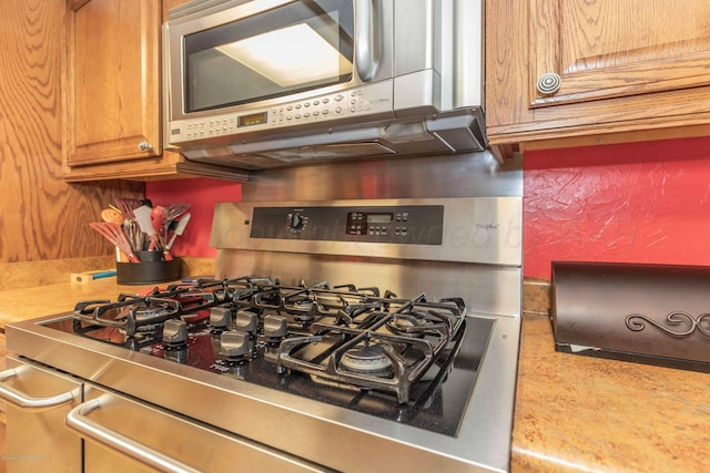 830 Burnett St, Miami, TX 79059 - interior details with light countertops, stainless steel microwave, brown cabinetry, and gas range oven