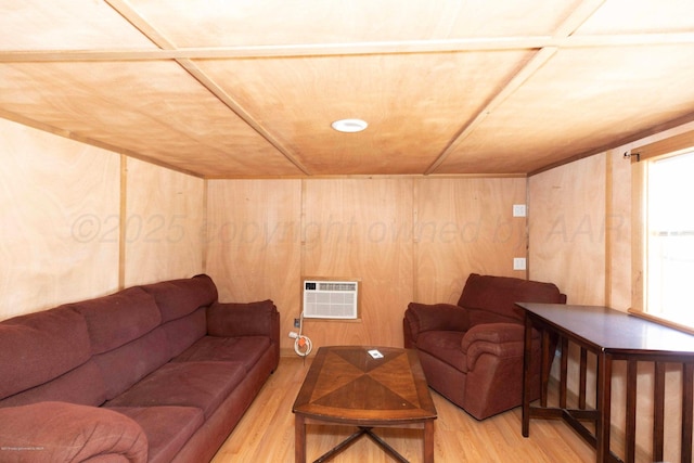 830 Burnett St, Miami, TX 79059 - living area with an AC wall unit, light wood-style floors, and wood walls