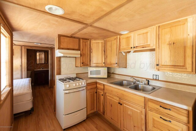 830 Burnett St, Miami, TX 79059 - kitchen featuring light countertops, white appliances, under cabinet range hood, a sink, and light wood-style floors