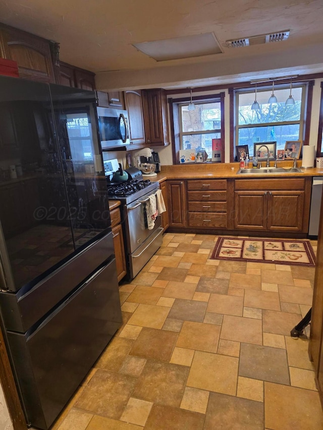 830 Burnett St, Miami, TX 79059 - kitchen with light countertops, a sink, a wealth of natural light, and appliances with stainless steel finishes