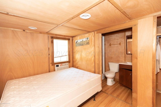 830 Burnett St, Miami, TX 79059 - bedroom with ensuite bath, wood finished floors, a wall unit AC, and wood walls