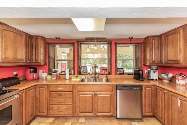 830 Burnett St, Miami, TX 79059 - kitchen with a sink, decorative light fixtures, appliances with stainless steel finishes, and brown cabinetry