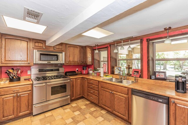 830 Burnett St, Miami, TX 79059 - kitchen with a sink, stainless steel appliances, brown cabinets, and visible vents