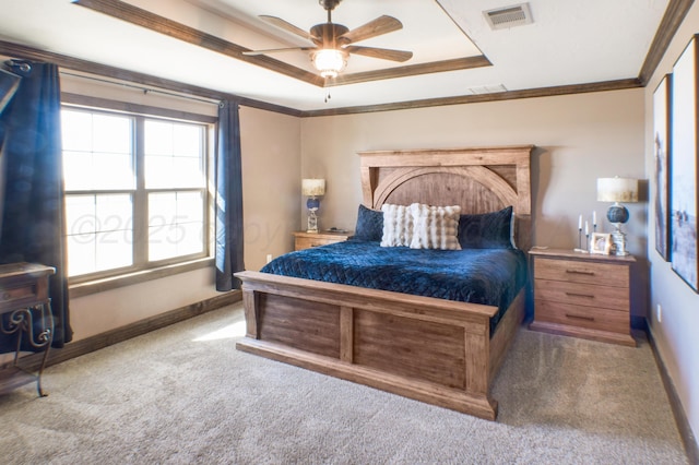 carpeted bedroom featuring baseboards, crown molding, visible vents, and a tray ceiling