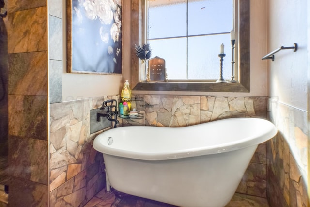 full bathroom featuring a soaking tub and tile walls