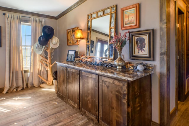 bar featuring light wood-style flooring and crown molding