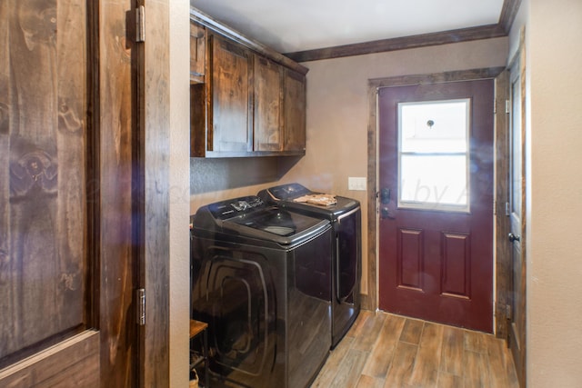 clothes washing area with separate washer and dryer, wood finished floors, cabinet space, and crown molding