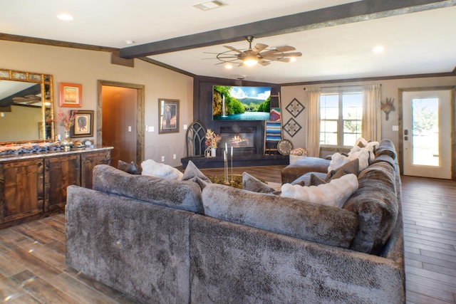 living area featuring ornamental molding, wood finished floors, a glass covered fireplace, and a ceiling fan