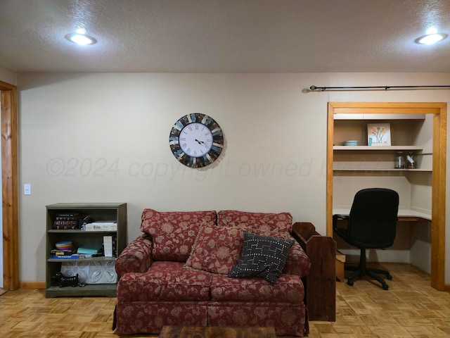 living room featuring light parquet flooring and a textured ceiling