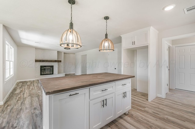 6011 Palmetto Trl, Amarillo, TX 79106 - kitchen featuring wooden counters, light wood-style flooring, baseboards, and white cabinetry