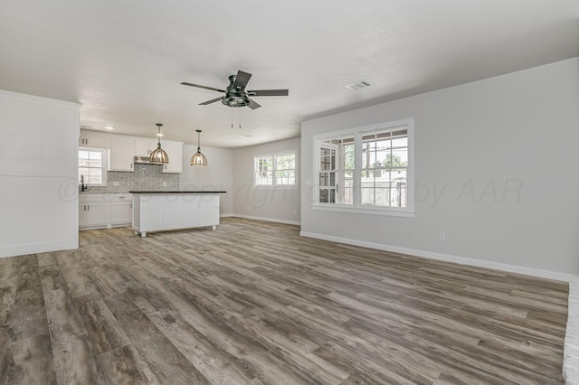 6011 Palmetto Trl, Amarillo, TX 79106 - unfurnished living room with wood finished floors, a ceiling fan, and baseboards