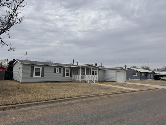 ranch-style home featuring covered porch, an attached garage, and concrete driveway