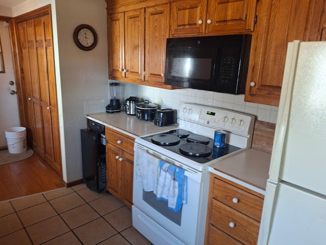 kitchen featuring light countertops, white appliances, brown cabinetry, and backsplash