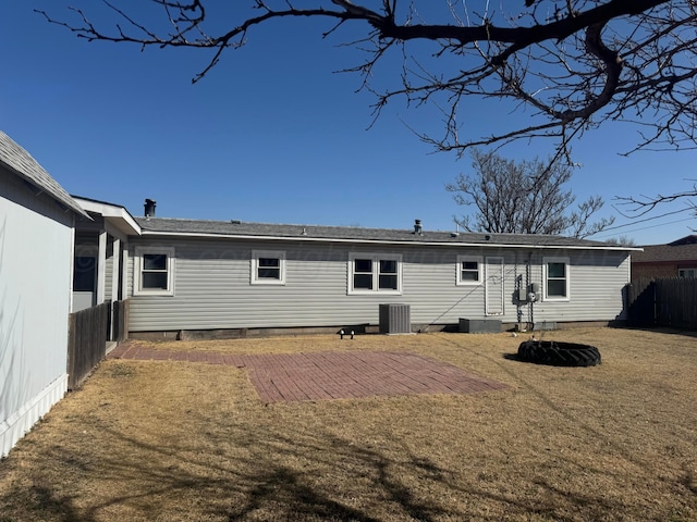 rear view of house featuring central AC, a lawn, a patio, and fence